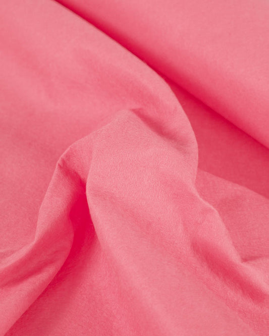 A gathered piece of rose pink wool and viscose felt fabric with a bold colour and structured texture.