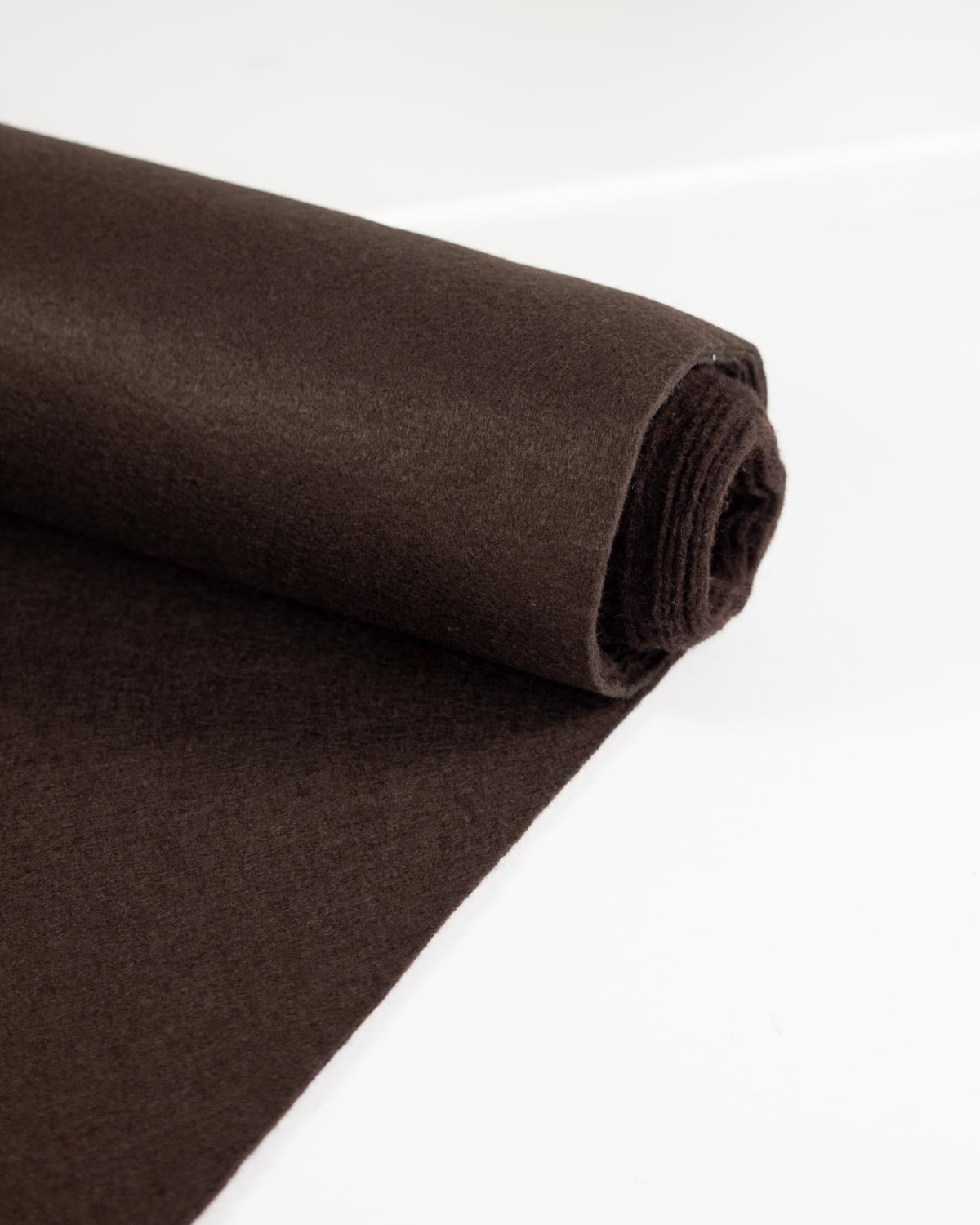 A roll of dark brown wool and viscose felt fabric, partially unrolled, shown on a clean white background.