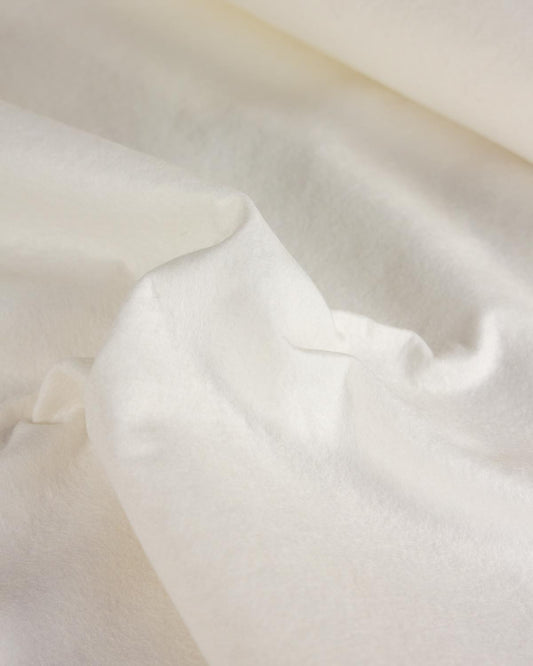 A close-up of soft, draped off-white wool and viscose felt fabric with a plush, velvety texture.