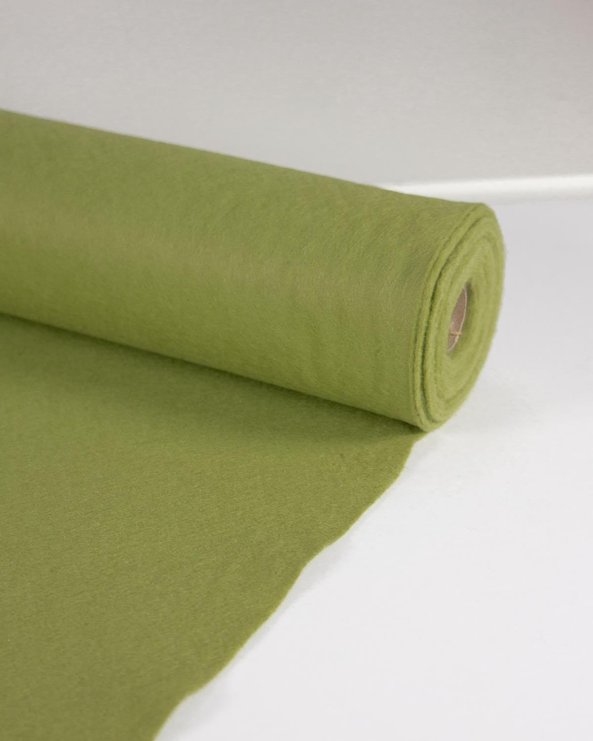 A roll of meadow marl green wool and viscose felt fabric rolled out, set against a clean white background.