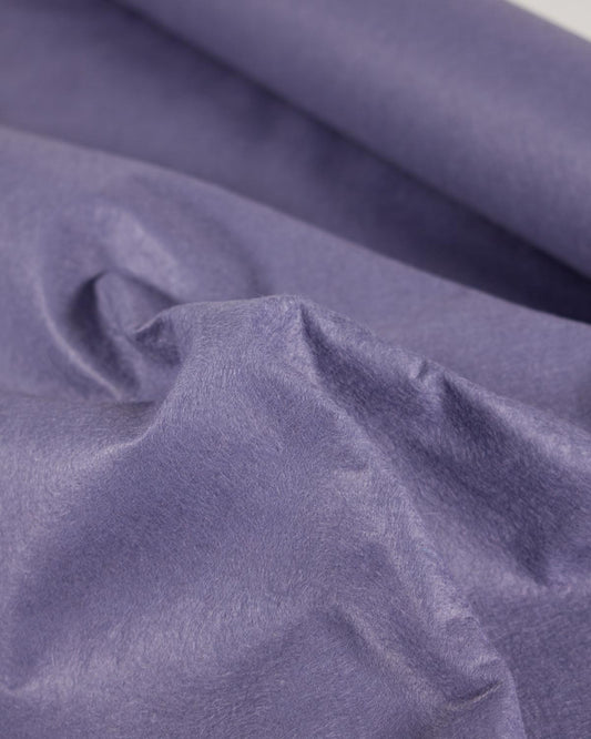 A close-up of draped lavender-purple wool blend craft felt fabric with a soft, slightly textured surface.