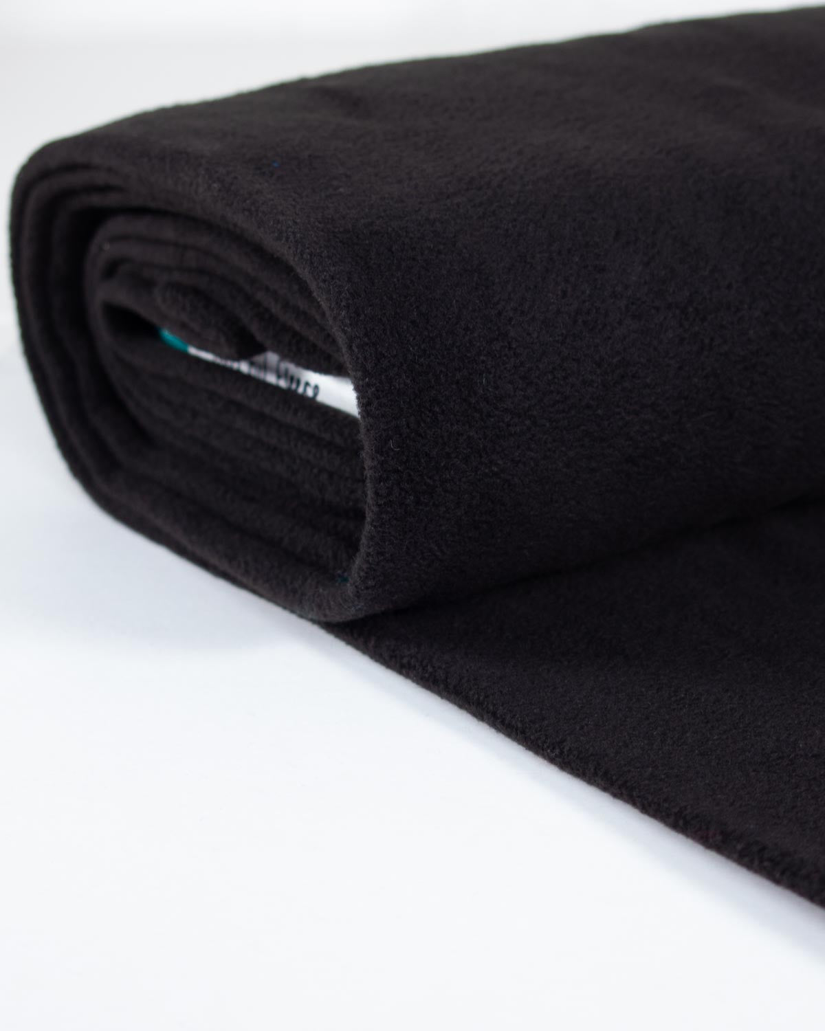 A close-up of a rolled black fleece fabric on a clean white background.