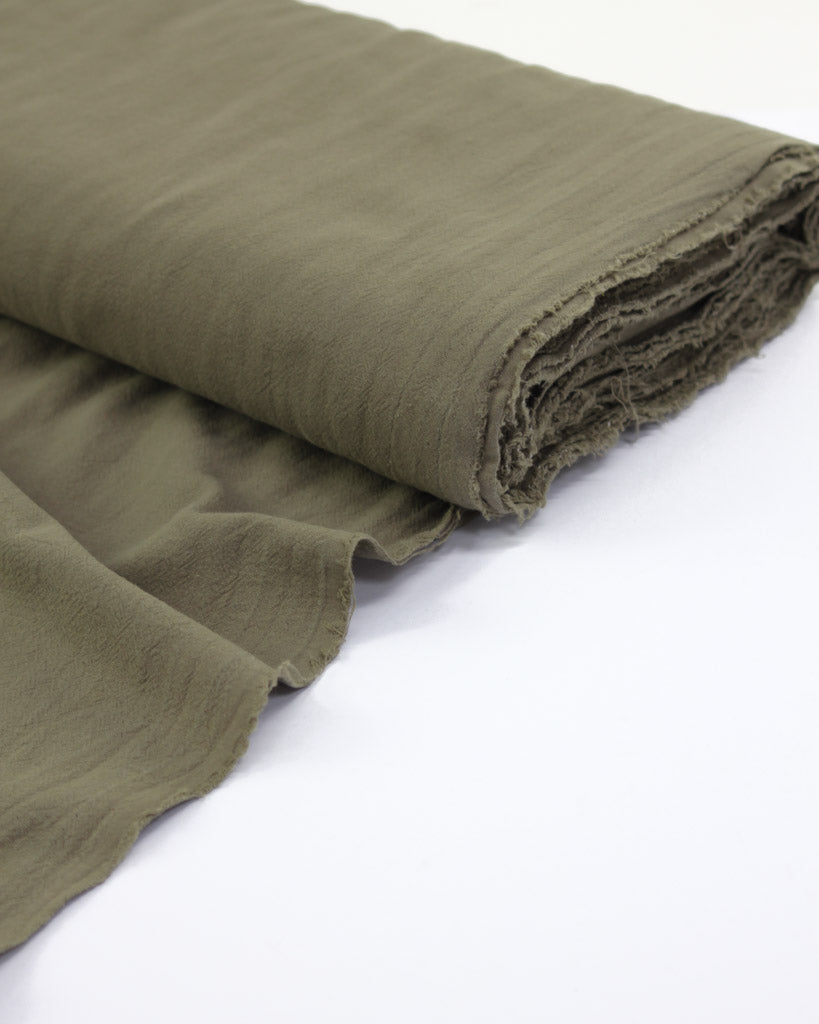 Bolt of crushed washed cotton fabric in a soft grey-green