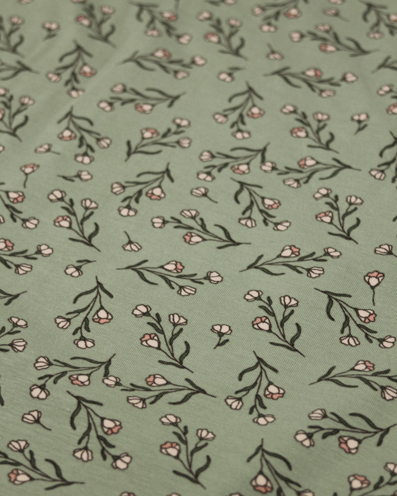 Close-up pattern of small flowers and leaves on a green background
