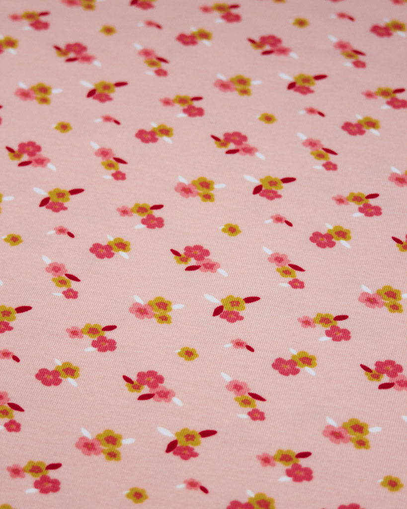 Ditsy floral pattern on a pink background, cotton jersey fabric.