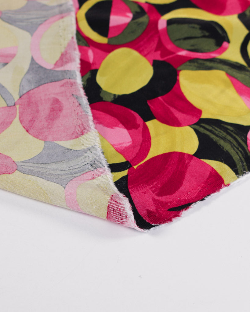 Close-up of colourful viscose satin fabric with abstract patterns on a white background