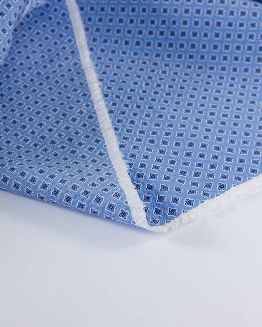 Lightweight blue seersucker cotton featuring a small repeating floral geometric design