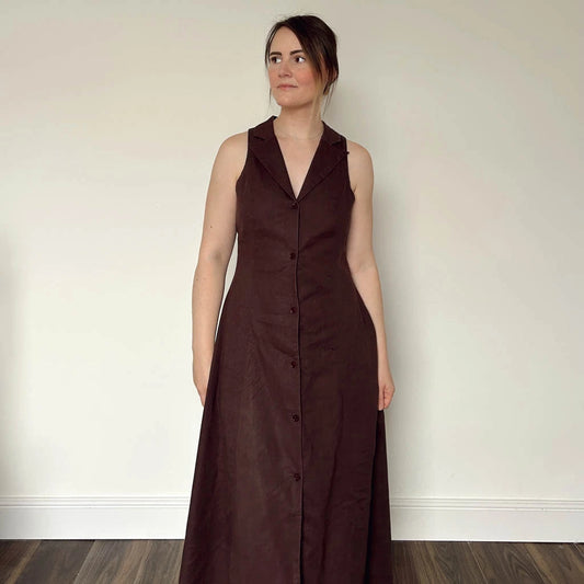 Woman wearing a long brown dress made using the Diana dress sewing pattern from NH Patterns
