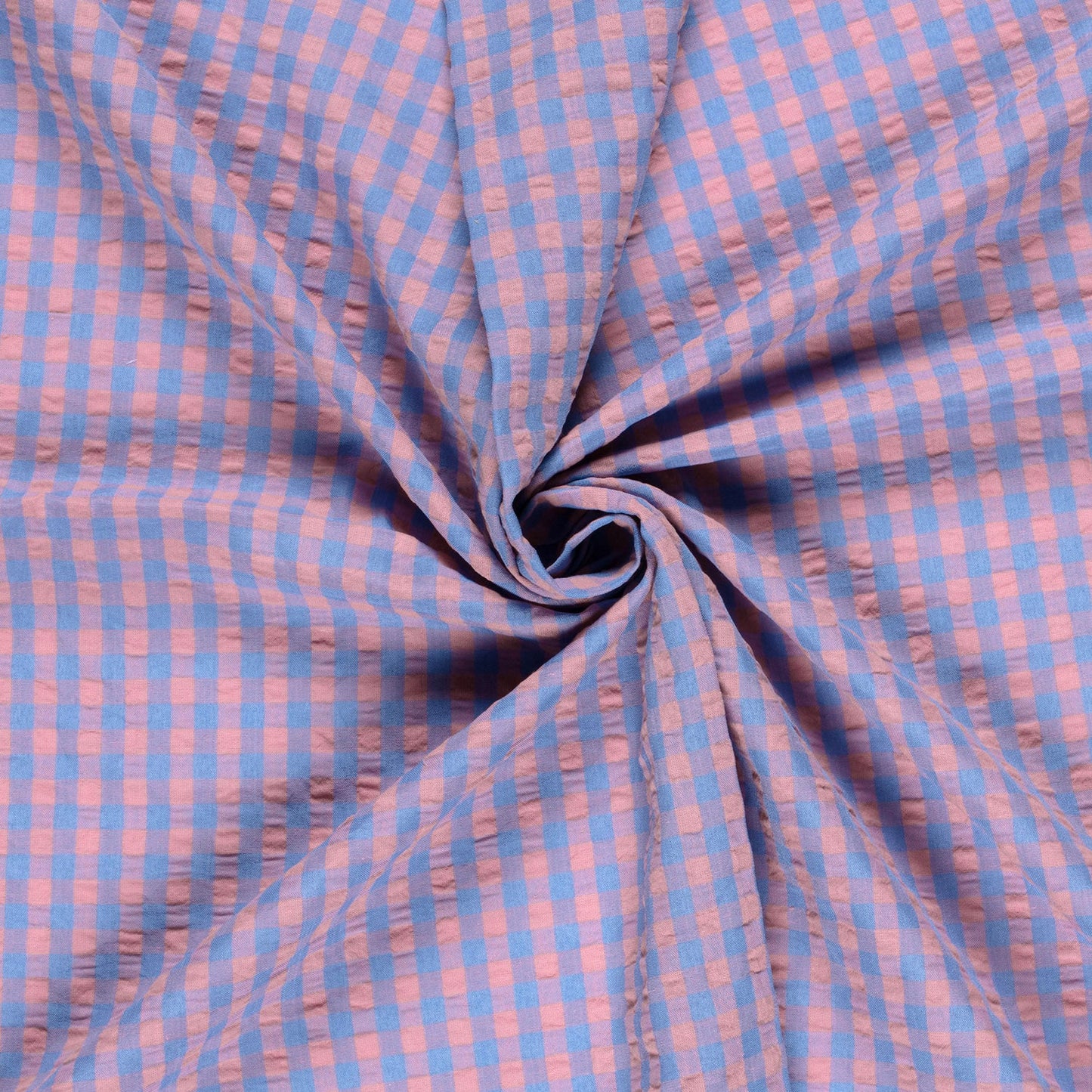Close-up of blue and pink checkered fabric in a swirl.