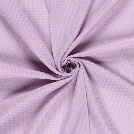 A close-up of lavender purple fabric arranged in a spiral swirl, showing a fine gingham or checkered texture.