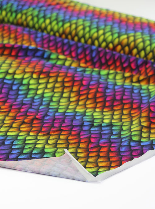 Multicolored dragon-scale pattern fabric on a white background