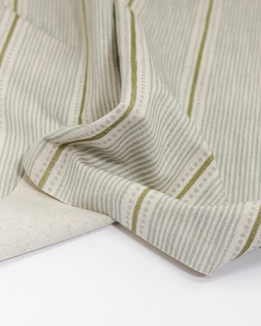 Close-up of astriped fabric with green stripes on a white background