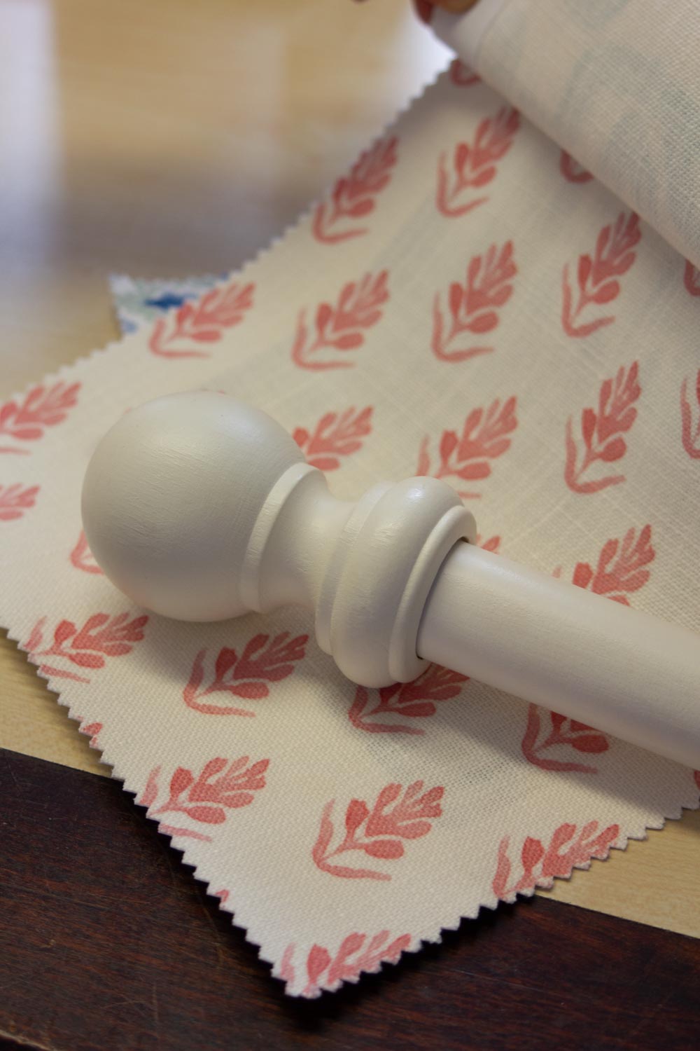 Colour-matched curtain pole displayed with fabric swatches