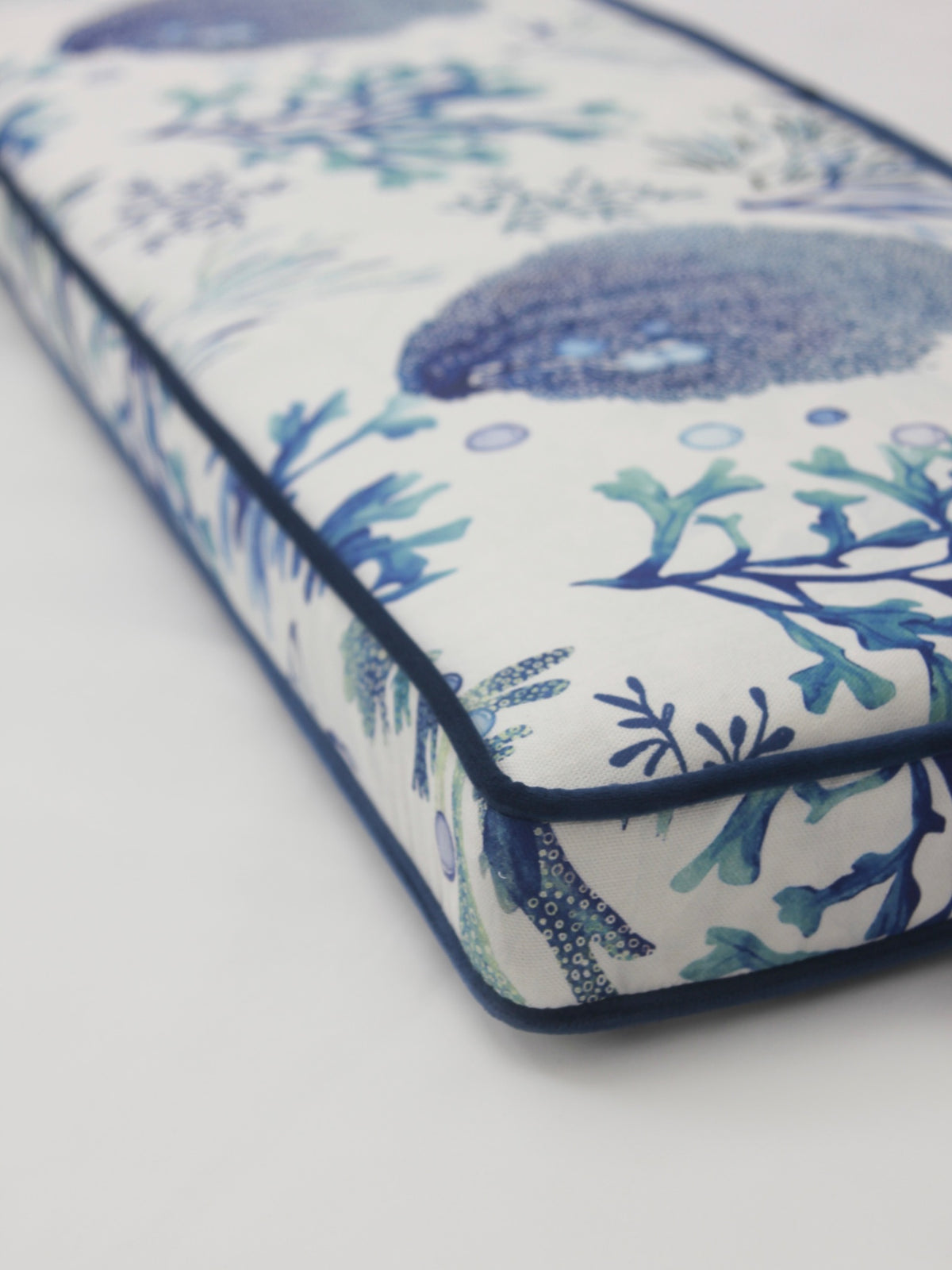 Close detail of a bespoke patterned box cushion with dark piping