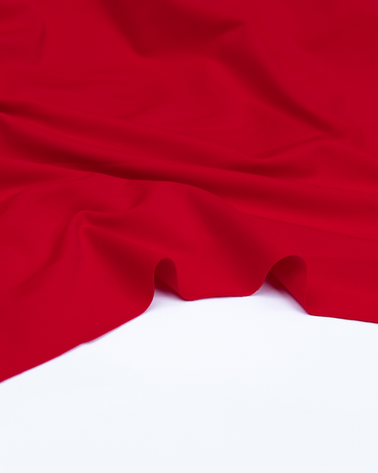 Close up shot of bright red stretch jersey fabric for sewing swimwear.