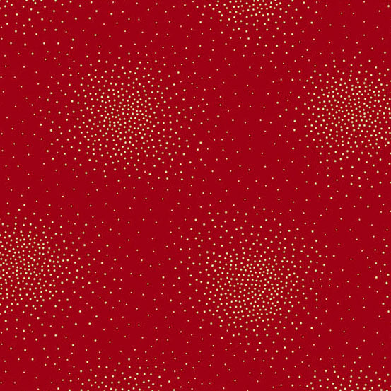 A close-up of a red cotton fabric with a repeating pattern of small metallic gold dots arranged in loose circular clusters.