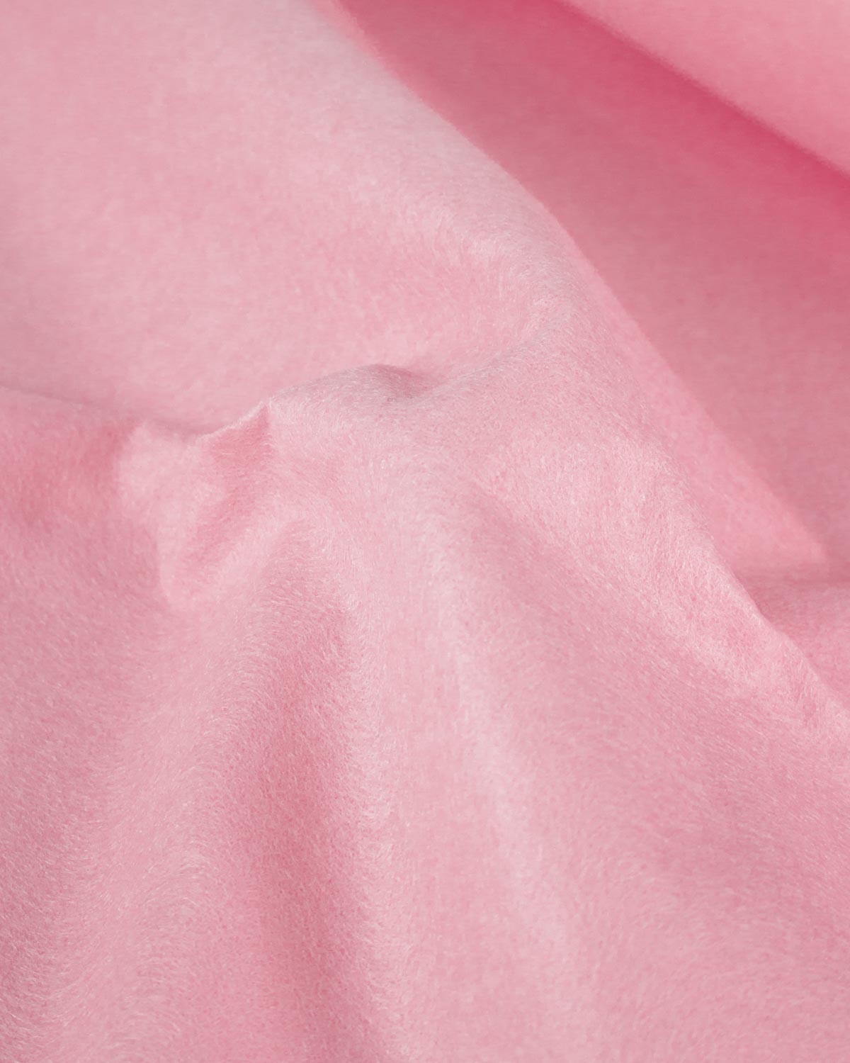 A piece of wool and viscose felt fabric, gathered up to show its texture and bright even colour. 