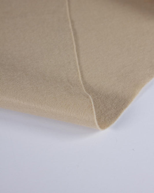 A close-up of a folded beige light stone wool and viscose fabric, showing its soft texture and smooth surface against a plain white background.
