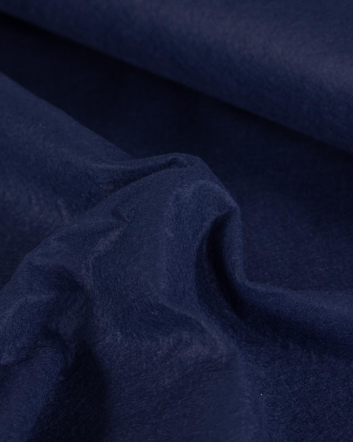 A close-up of draped navy blue wool and viscose felt fabric with a soft, slightly textured surface.