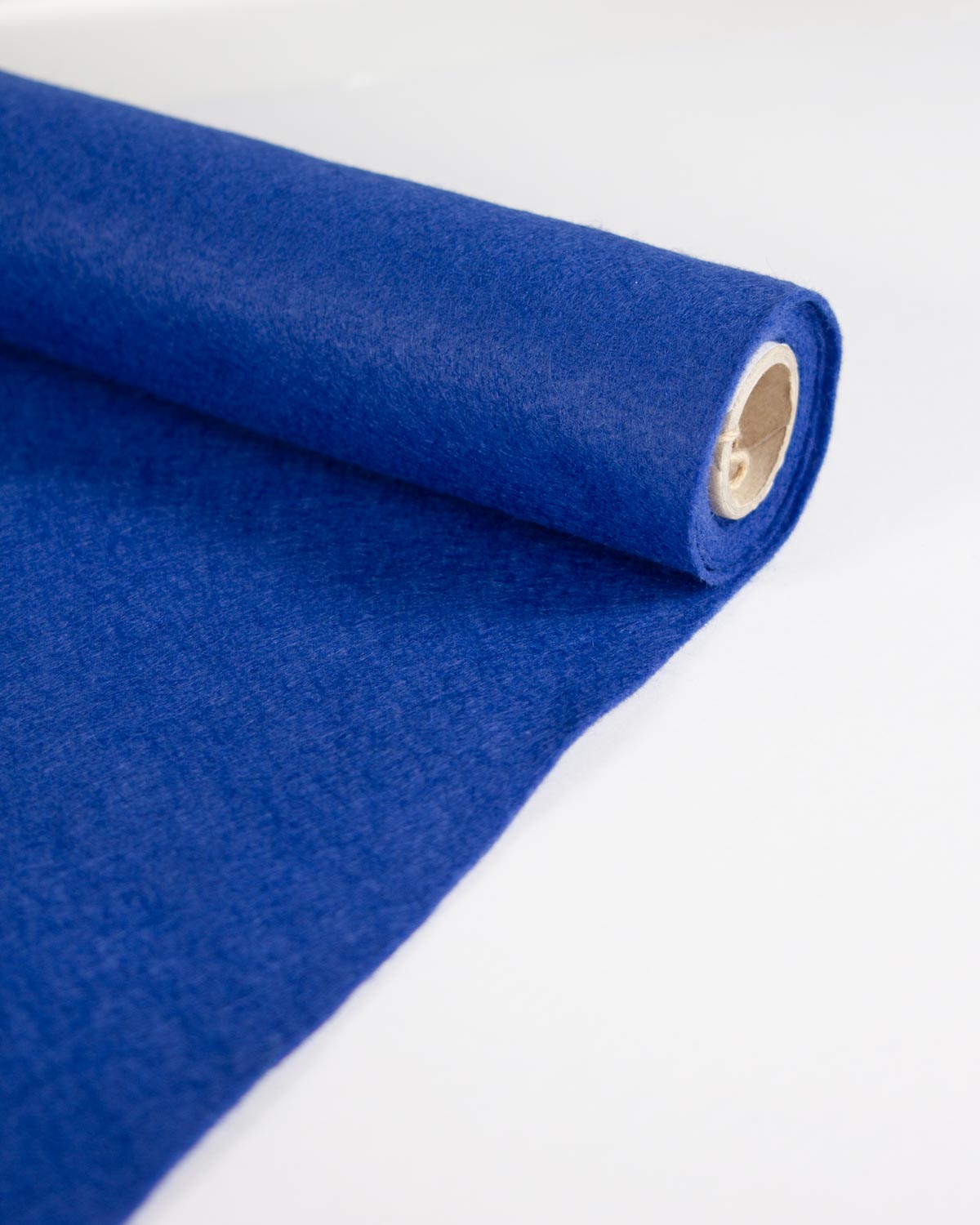 A close-up of a vibrant royal blue wool and viscose felt fabric roll, partially unrolled to show its soft, matte texture, set against a clean white background.