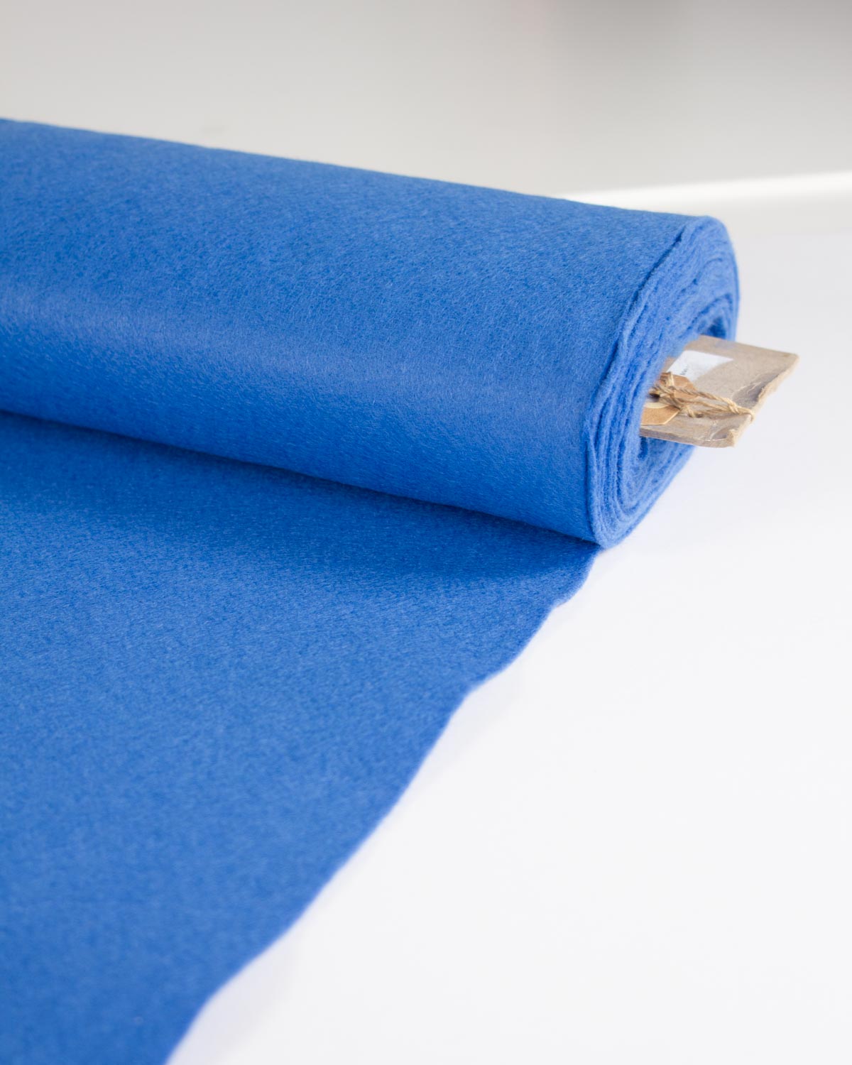 A roll of bright blue wool and viscose felt fabric, shown on a clean white background.