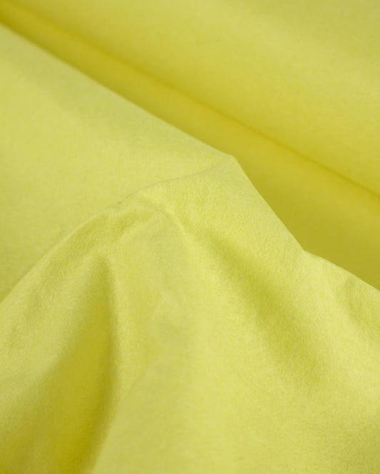 A scrunched up piece of bright lemon-yellow wool and viscose felt fabric, showing its bold colour and textured surface. 