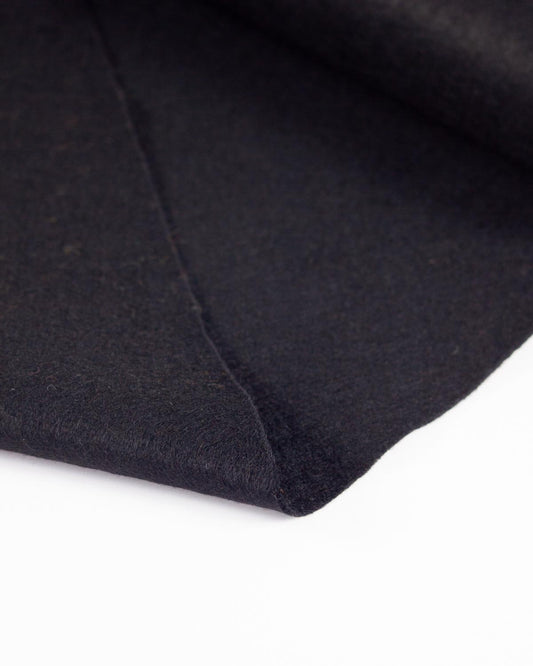 A close-up of a folded black wool and viscose felt fabric, showing its soft texture and matte finish against a clean white background.