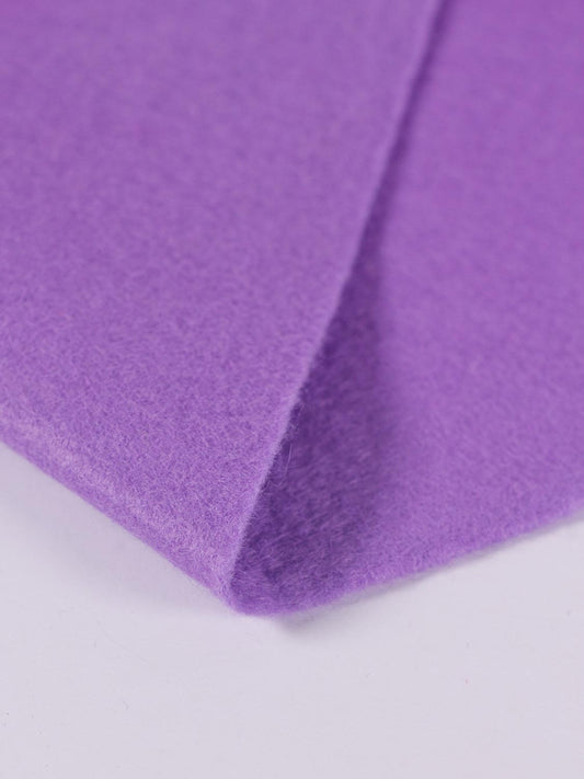 A piece of lilac purple wool and viscose felt, folded on a white background, showing its texture and even, bold colour.