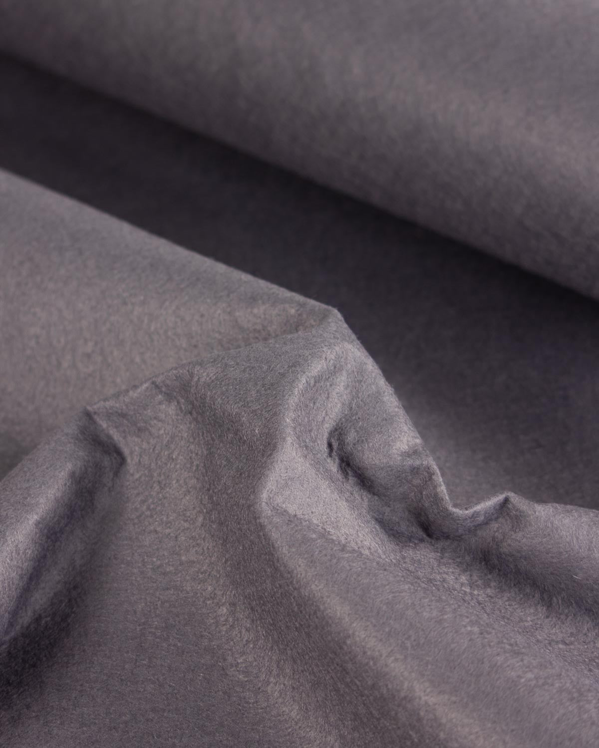 A close-up of draped grey wool and viscose felt fabric with a soft, slightly textured surface and folds.