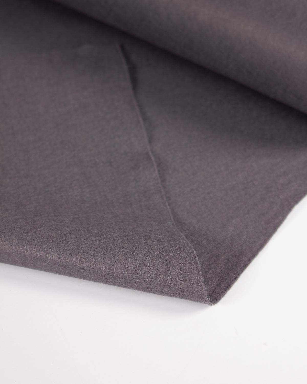 A close-up of folded dark grey wool and felt fabric showing its soft texture and matte finish on a clean white background.