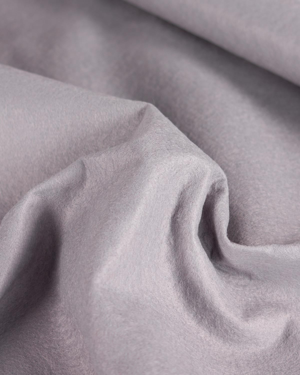 A close-up of draped light grey wool and viscose felt fabric with soft folds and a smooth, slightly matte texture.