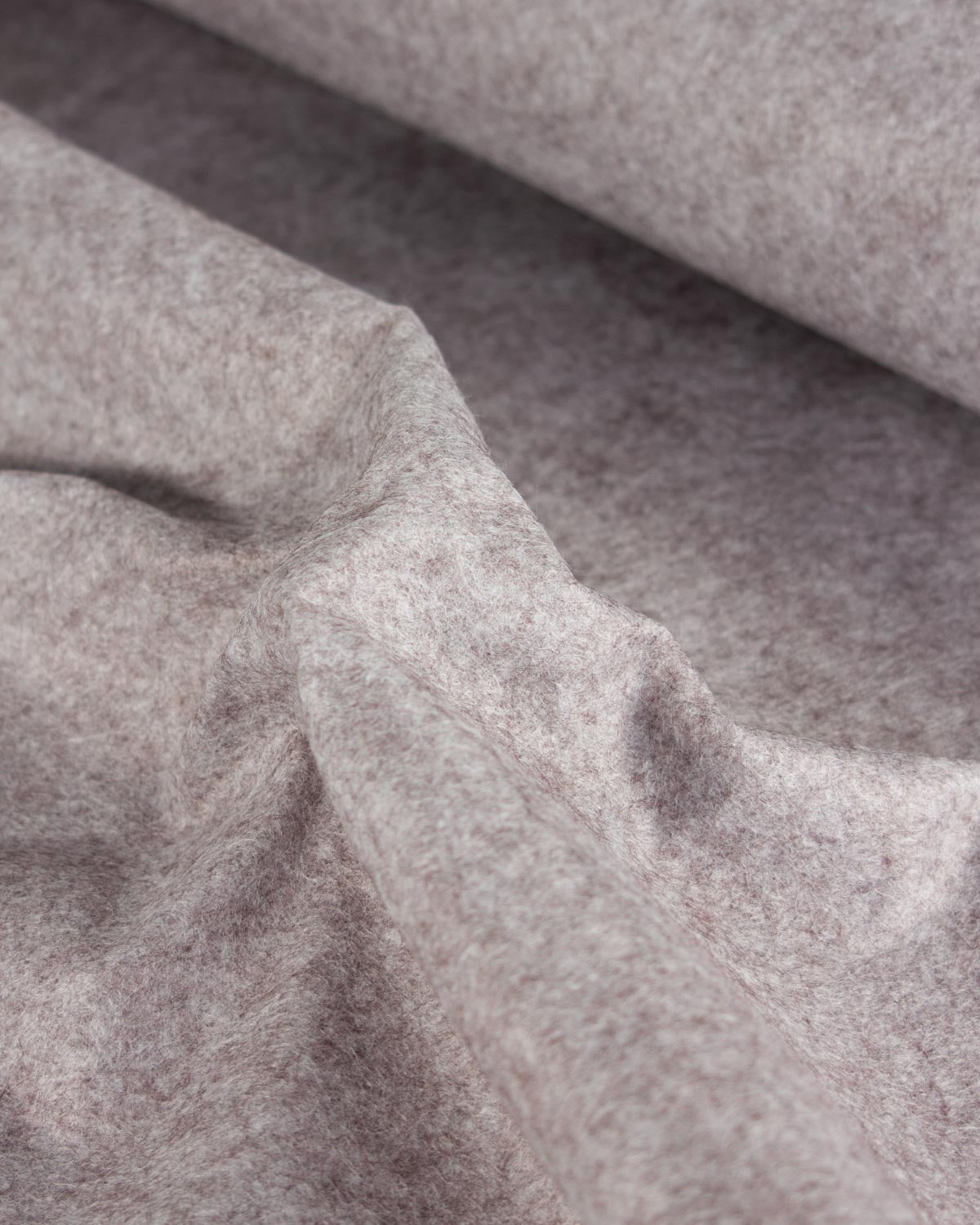 A close-up of draped wool and viscose felt fabric in a heathered taupe-gray color, showing its soft, textured surface and fine fibrous structure.