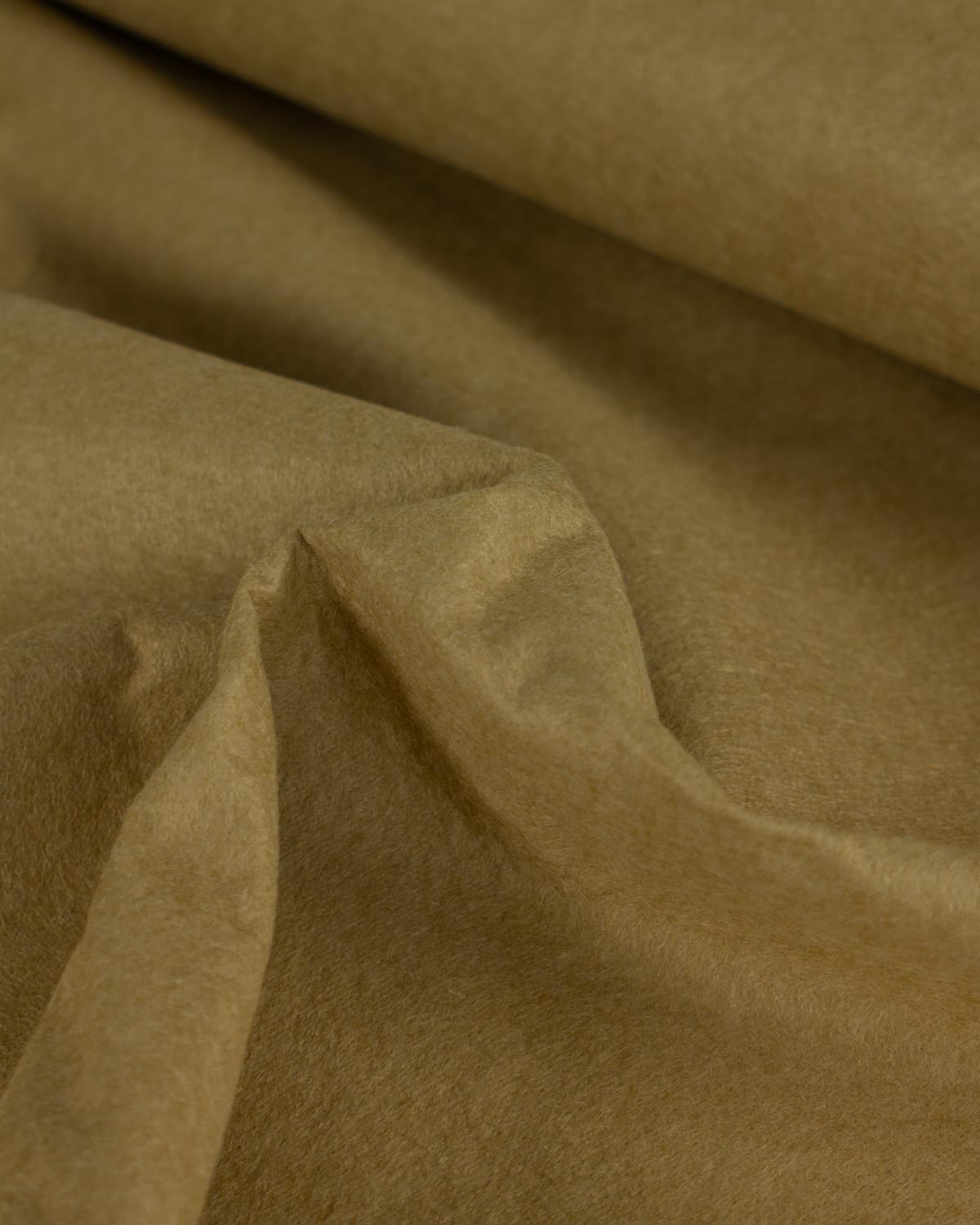 A close-up of draped wool and viscose felt fabric in a warm mustard olive color, showing the soft texture and folds of the material.