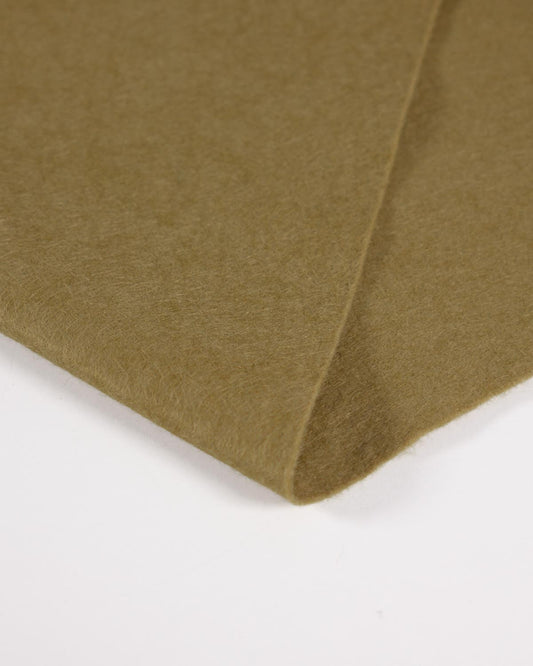 A close-up of a folded mustard olive yellow-green felt fabric showing its soft texture against a plain white background.