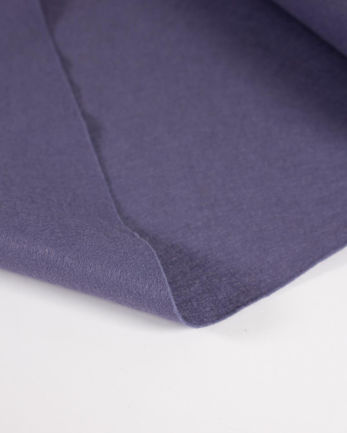 A close-up of wool blend craft felt fabric in a muted purple or dusty violet color, showing the texture and drape against a plain white background.