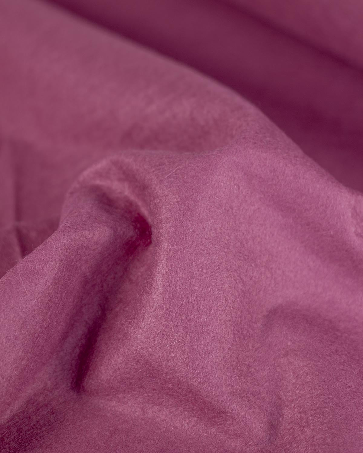 A close-up of draped raspberry pink/purple colored wool and viscose felt fabric with a soft, slightly fuzzy texture.
