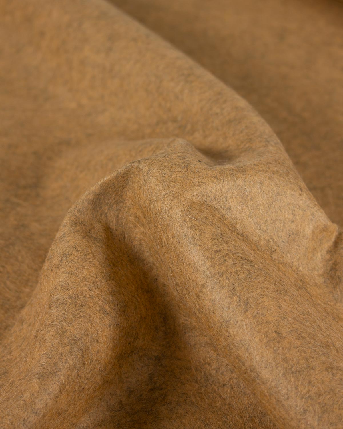 A close-up of draped yellow/gold marl wool and viscose felt fabric with a soft, textured surface.