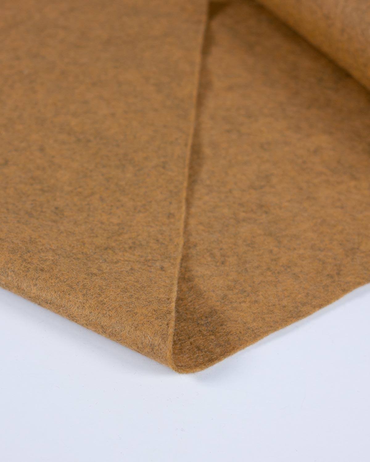 A close-up of a folded yellow gold marl wool and viscose felt fabric on a plain white background to show its texture and marled surface. 