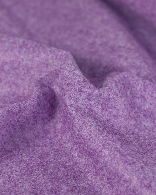 A close-up of draped heather marl purple wool and viscose felt fabric showing its soft, textured and marled surface.