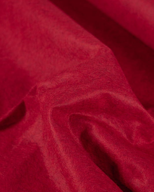 A close-up of draped red marl wool and viscose felt fabric with a soft, velvety texture and gentle folds.