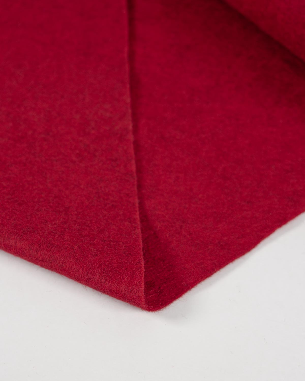 A close-up of folded marl red wool and viscose felt fabric showing its soft, marled textured surface on a plain white background.