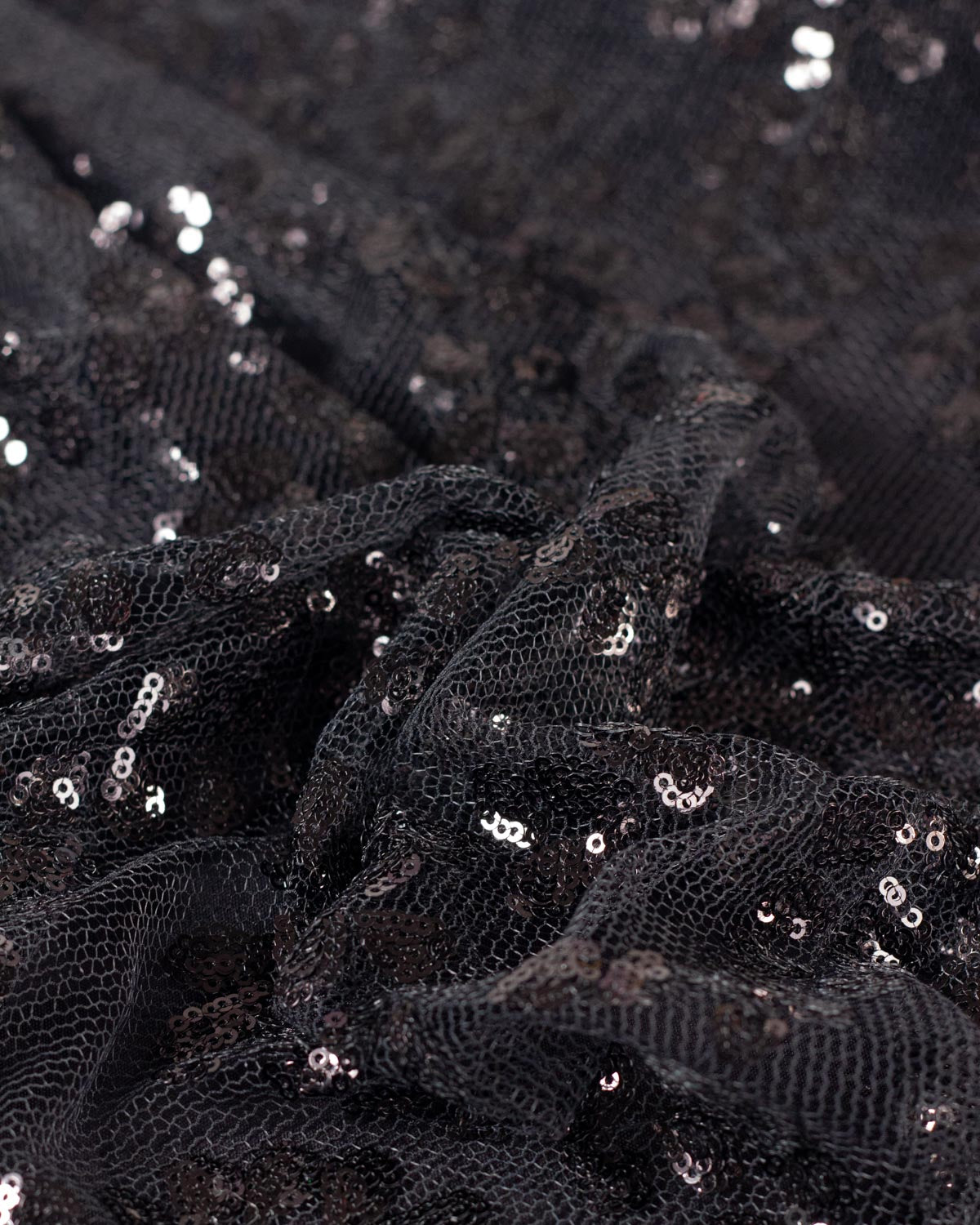 A gathered piece black sequined tulle featuring small black sequins. 
