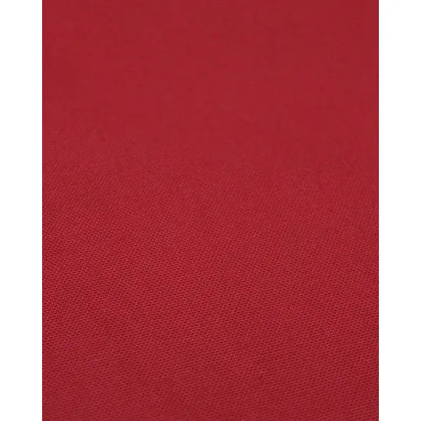 Close up of poppy red pure cotton canvas fabric showing woven surface
