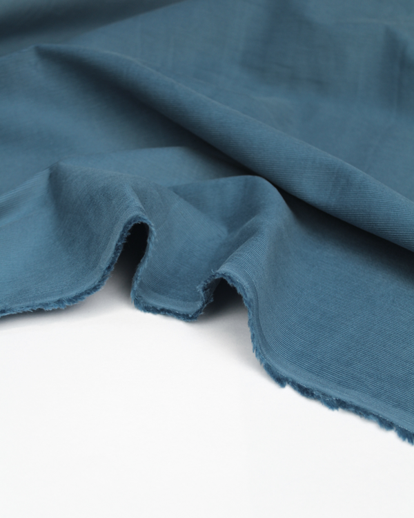 Close up of delph blue pure cotton babycord fabric showing fine cord texture