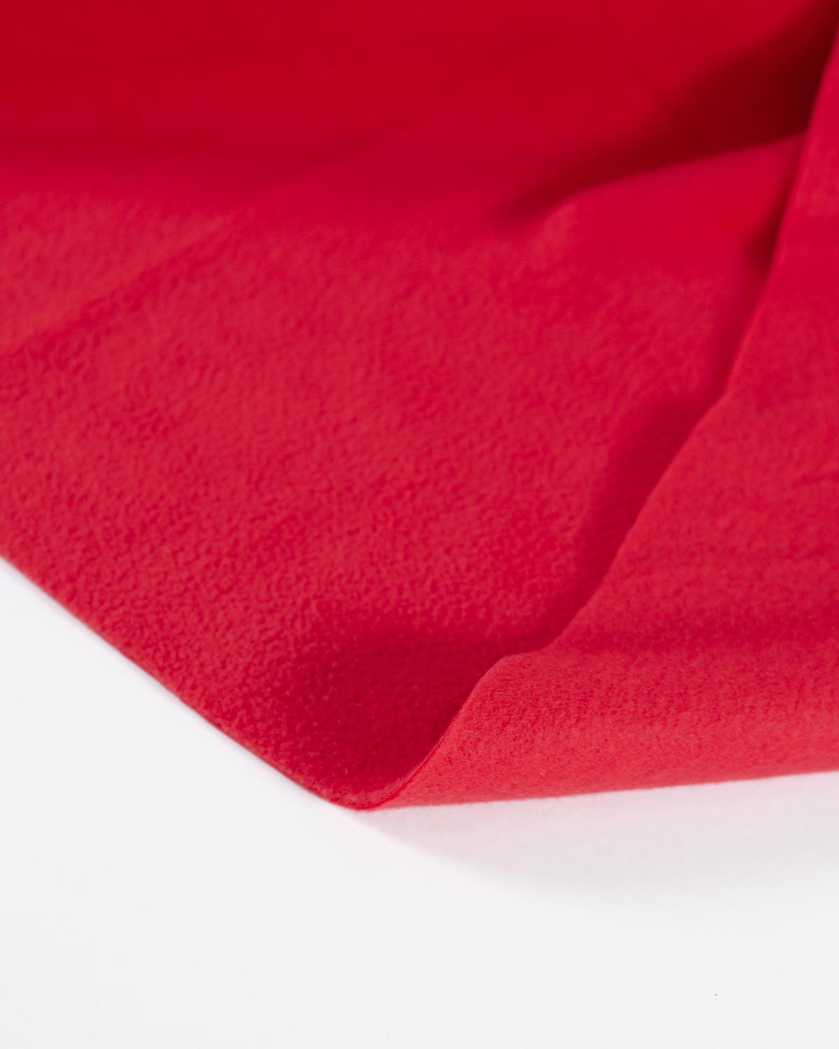 A close-up of bright red fleece fabric on a white background, showing a soft textured surface and gentle folds.