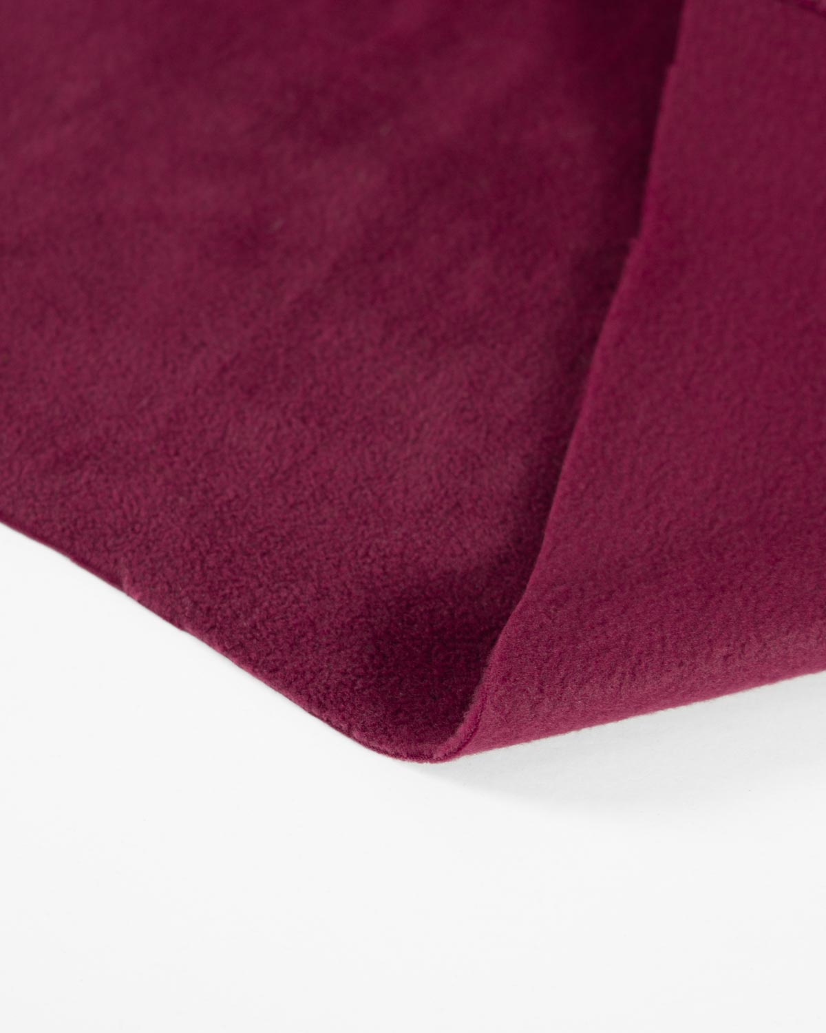 A close-up of a deep burgundy, wine red colour plush fabric, showing its soft texture and folded corner against a plain white background.