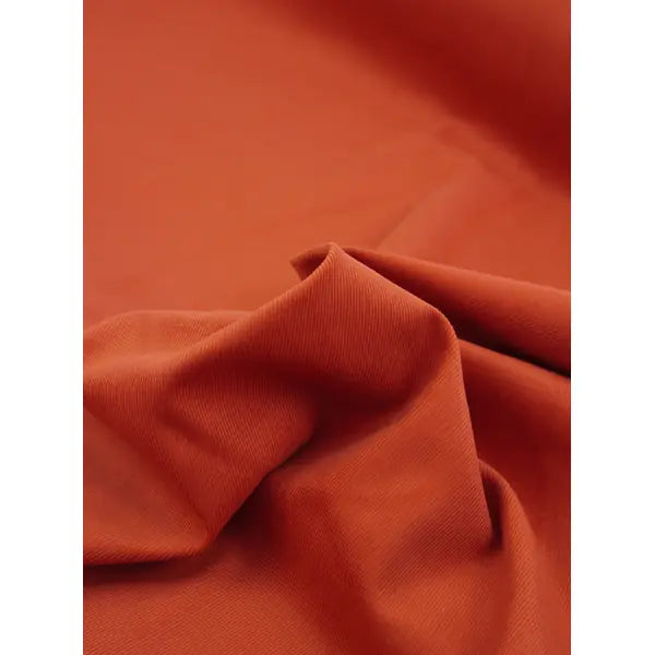 Close up of persimmon pure cotton babycord fabric with soft narrow wale texture