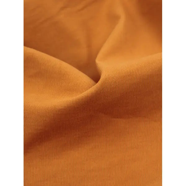 Super close up of turmeric pure cotton babycord fabric with soft fine corduroy ribs