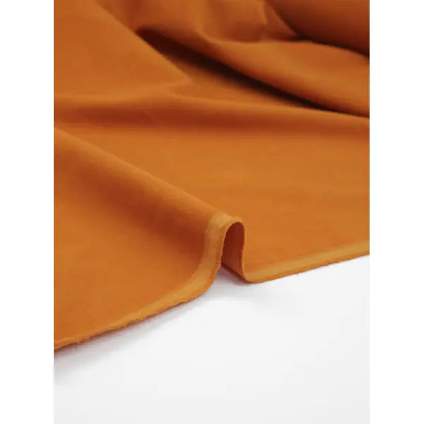 Selvedge view of turmeric pure cotton babycord fabric with soft fine corduroy ribs