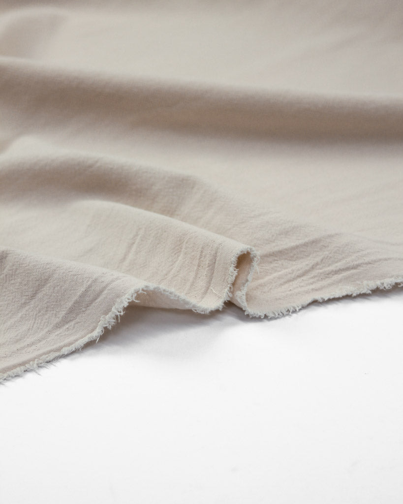 Selvedge edge of crinkle washed cotton fabric in off white